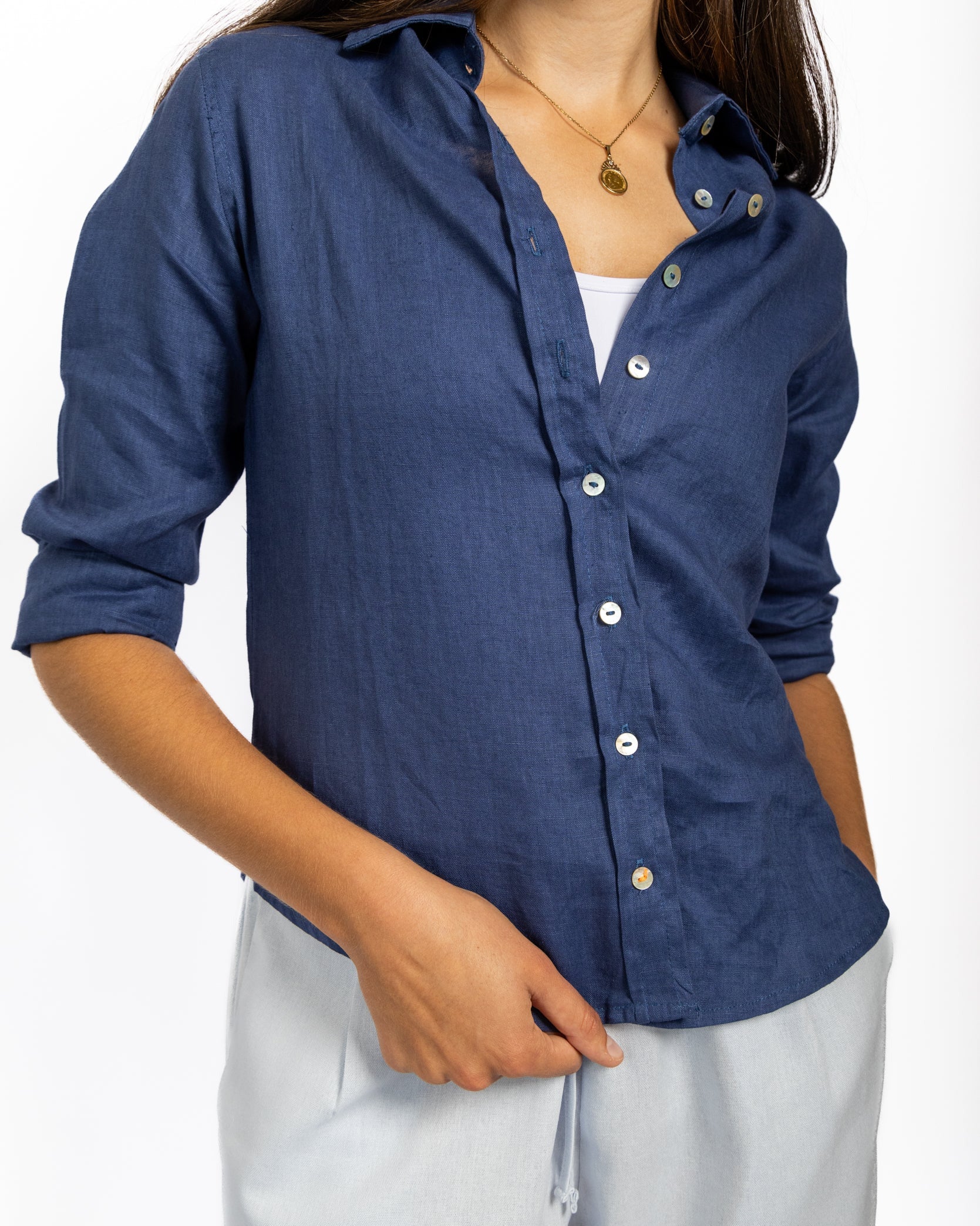 Person wearing a blue button-up shirt with a white background