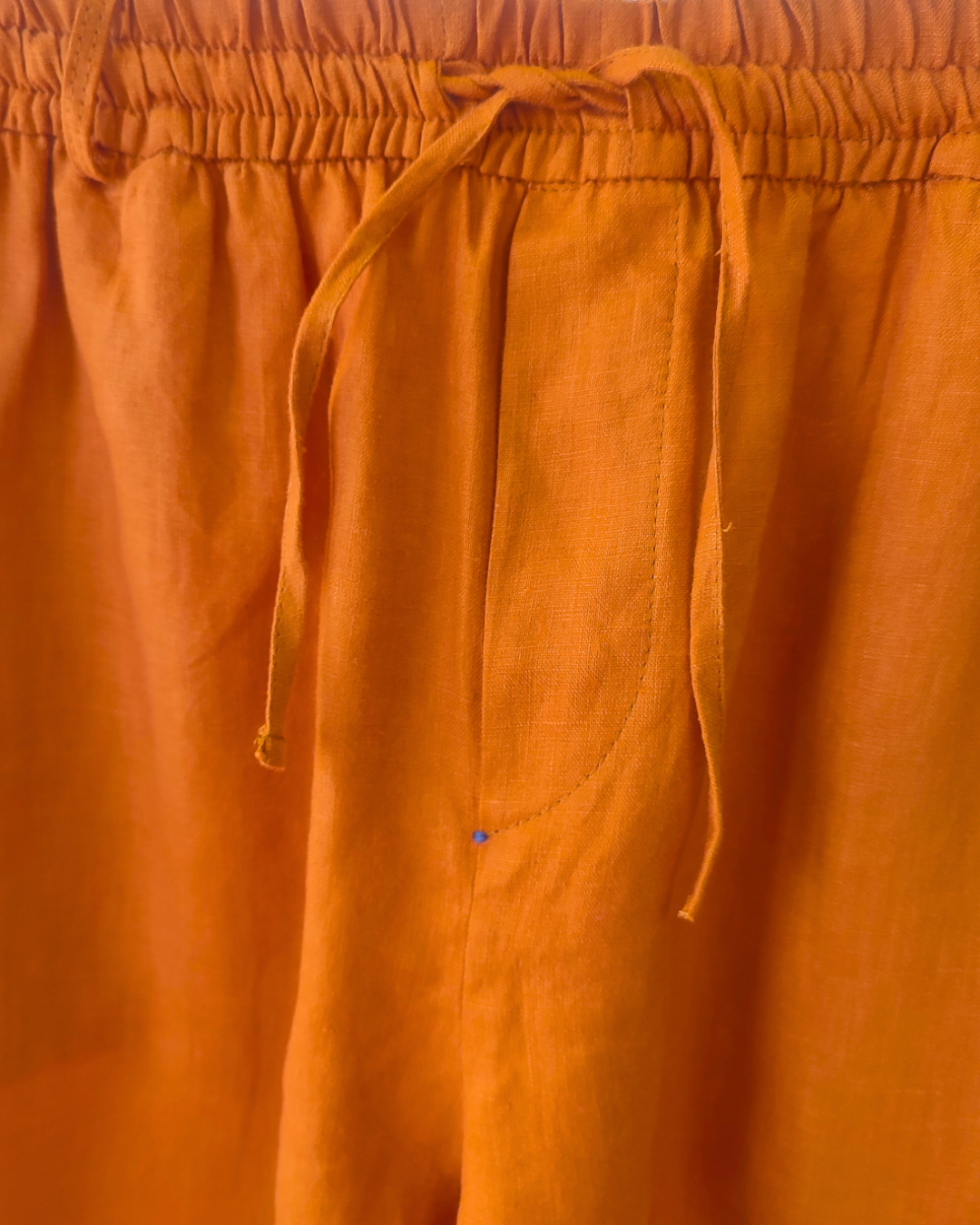 Close-up of orange pants with drawstring waistband